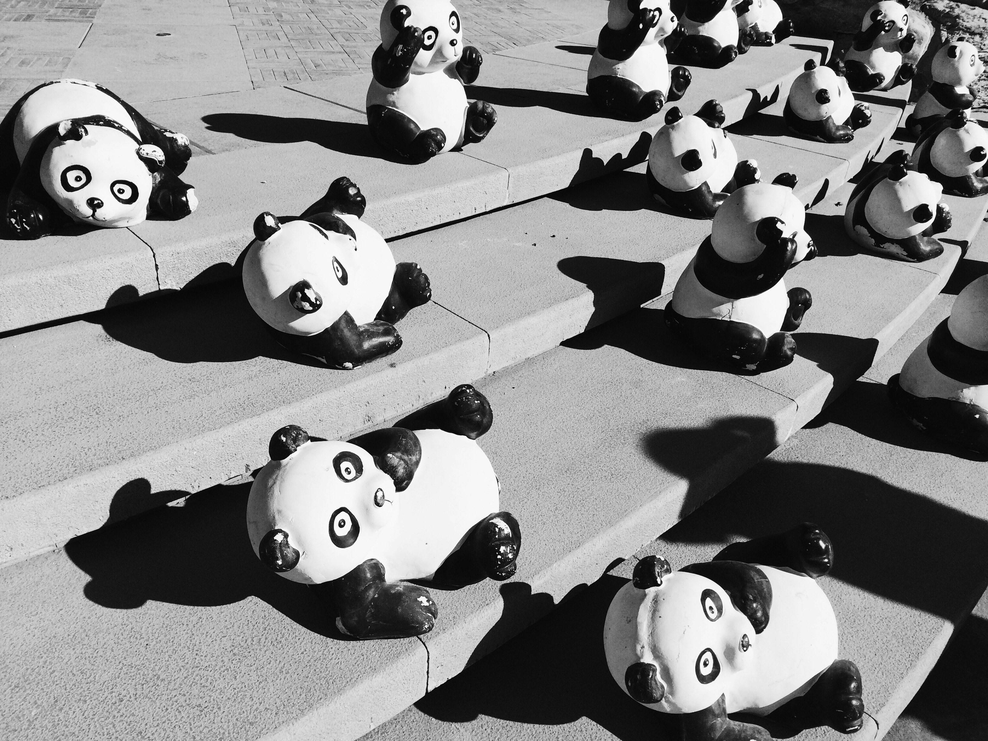 Panda statues on gray concrete stairs during daytime