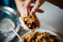 Chef preparing rice balls in an open kitchen with fresh ingredients around.