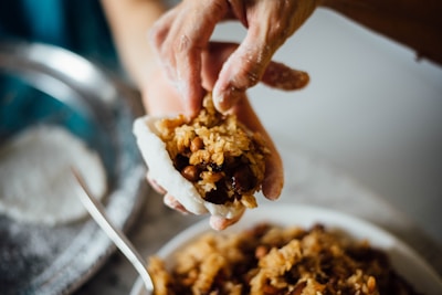 Chef preparing rice balls in an open kitchen with fresh ingredients around.