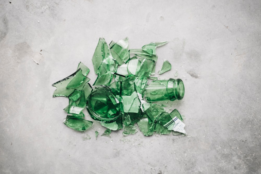 Zerbrochene grüne Glasflasche auf dem Boden
