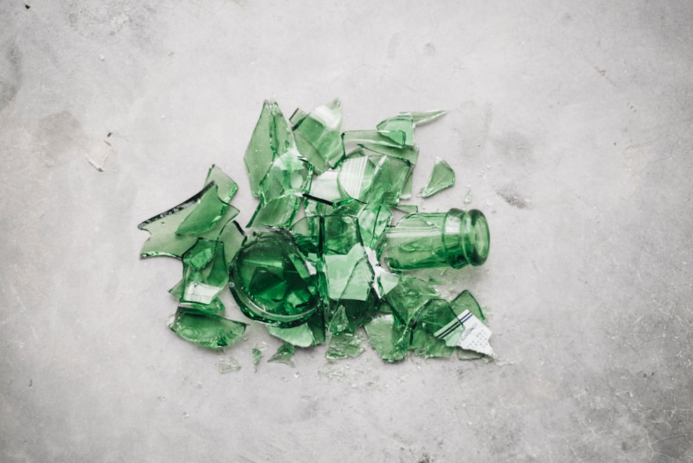 broken green glass bottle on the ground