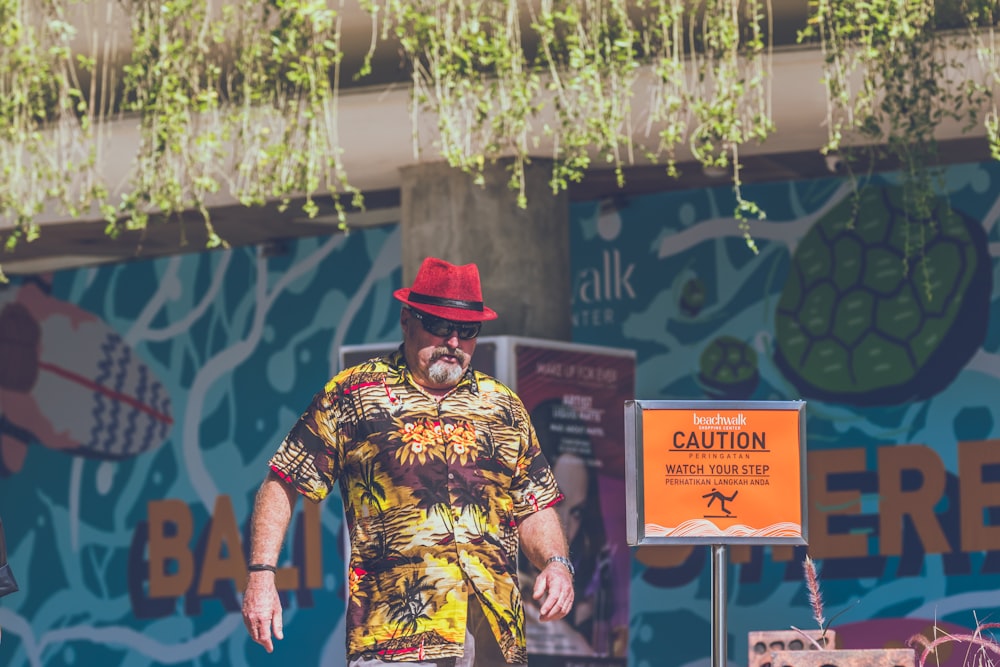 man standing near caution signage