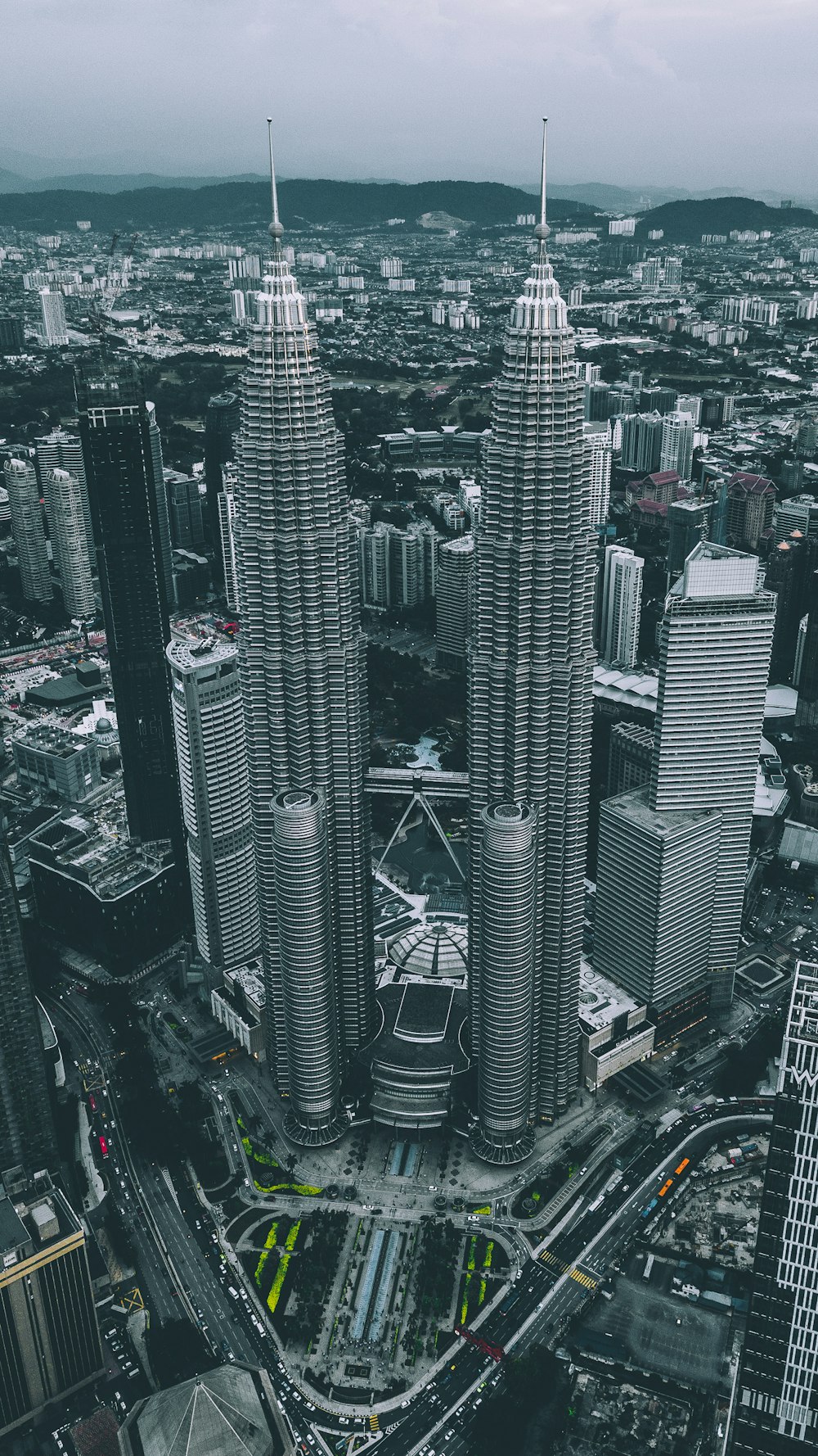 灰色の空の下で灰色のツインタワーのコンクリートの建物の空中写真