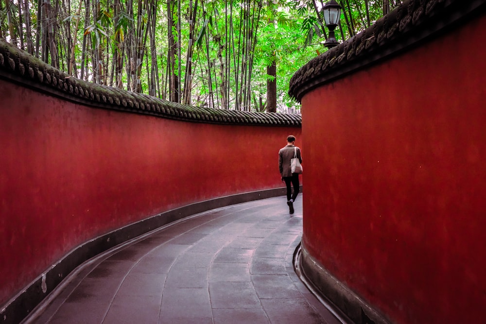 man walking on hallway surround by trees