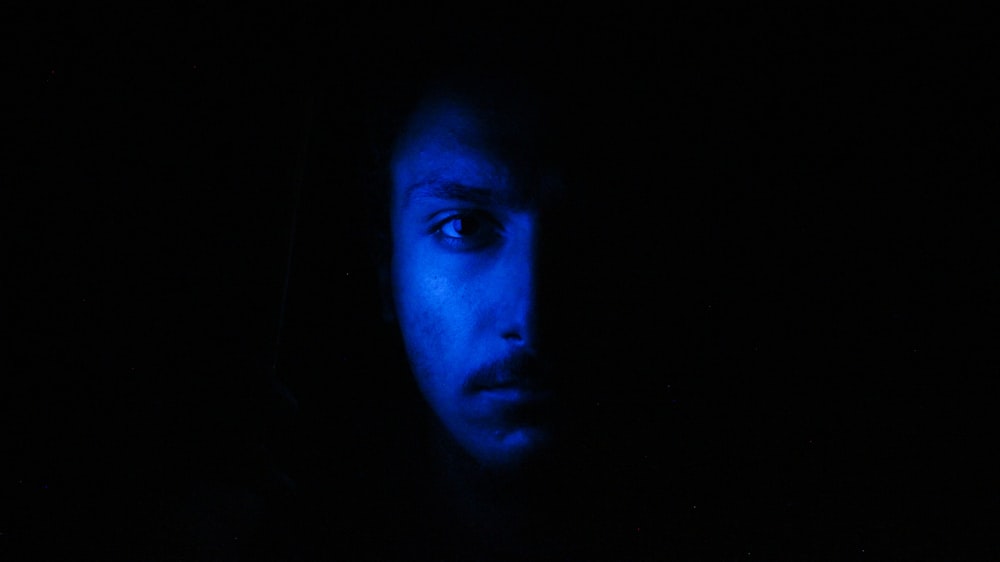 la cara del hombre contra la luz azul