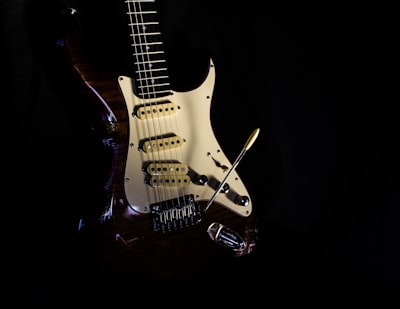 selective focus photography of white and red electric guitar instrument teams background