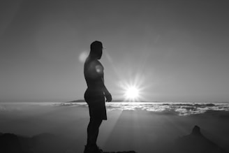 A sunset silhouette of Scott standing on a mountain peak, symbolizing the journey toward one’s legend.