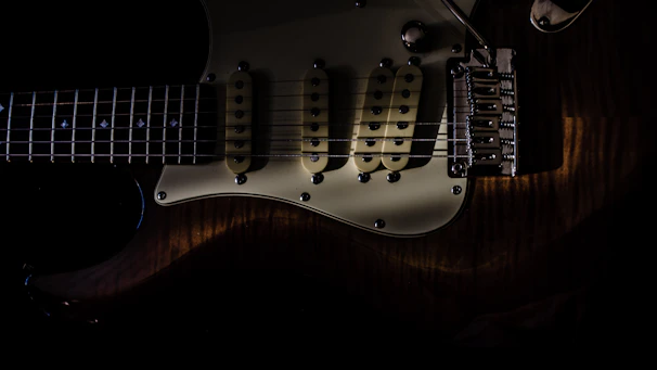 A finished custom guitar glowing under studio lights, emphasizing the blend of modern design and traditional craftsmanship.