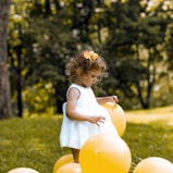 girl wearing white sleeveless dress beside balloons