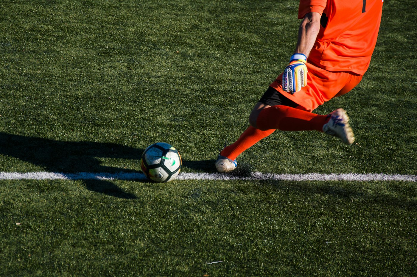 サッカー場でボールを蹴る選手