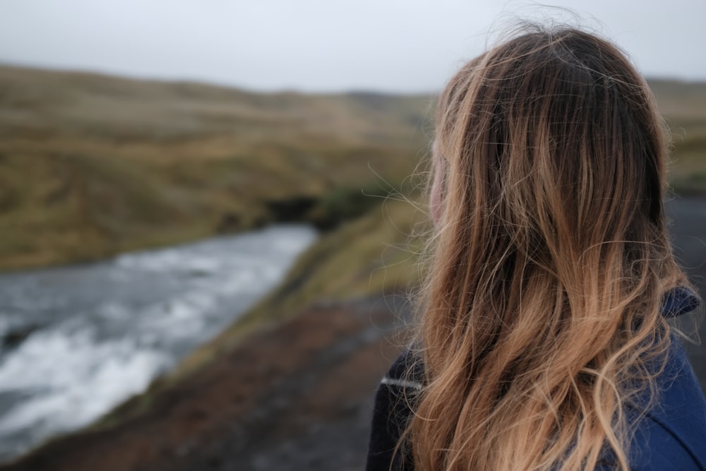 woman facing on body of water at daytime