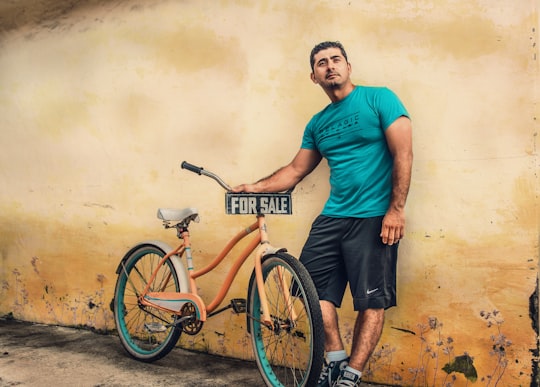 man holding orange beach cruiser in Hialeah United States