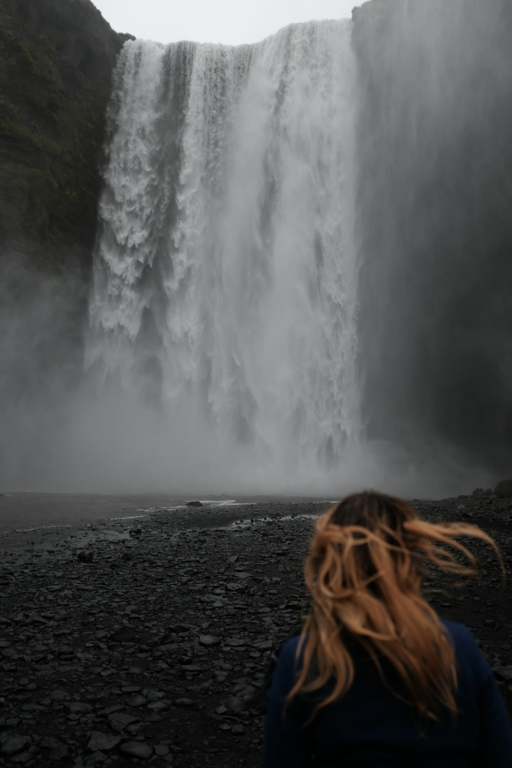 woman standing near waterfalls