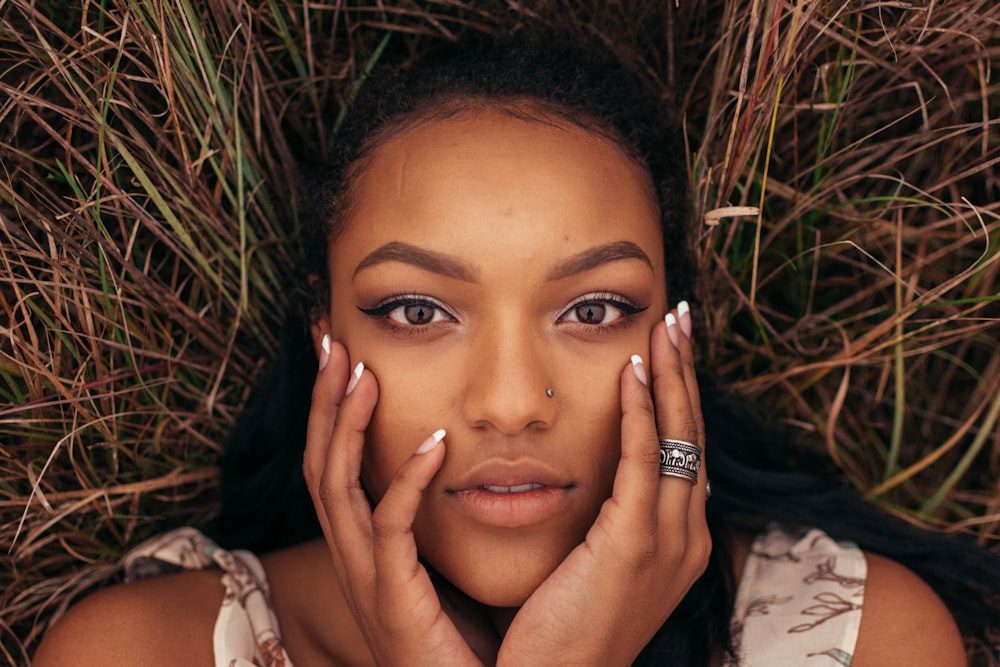 woman lying on brown grass while being photograph