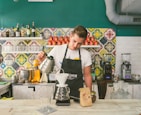 Barista preparing a pour-over coffee in a cozy cafe setting