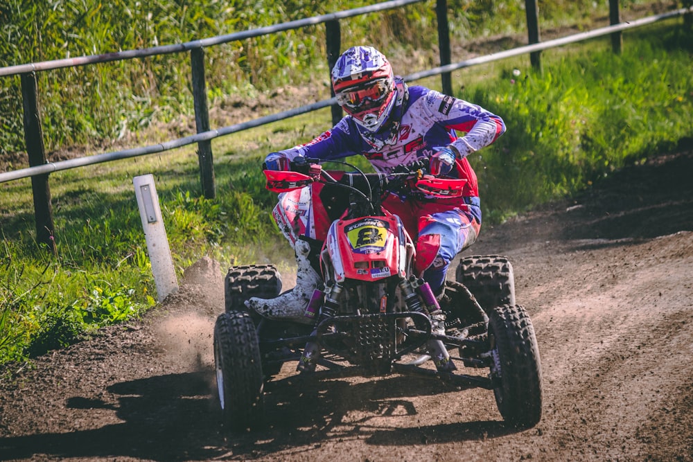 man riding red and black all-terrain vehicle