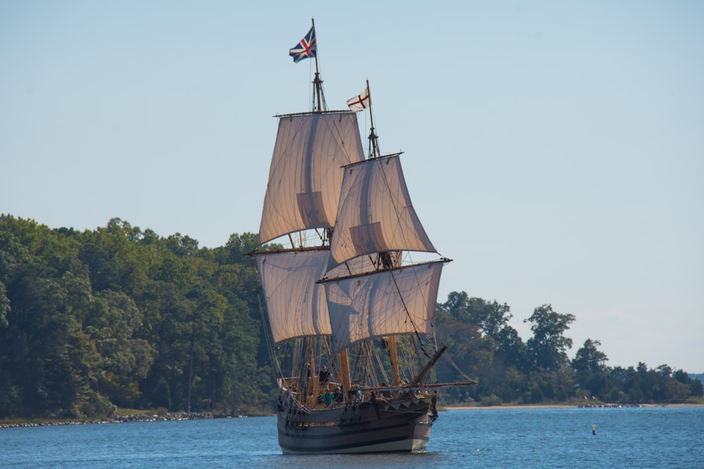 brown galleon ship on body of water near trees