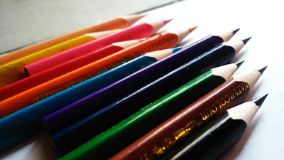 A vibrant set of colored pencils arranged in a neat row on white paper.