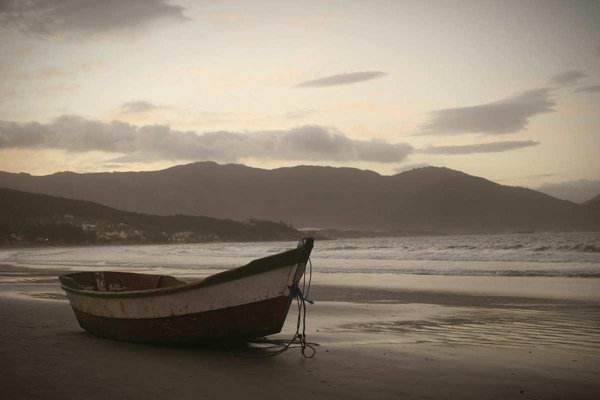 A small wooden boat on a beach at dusk
