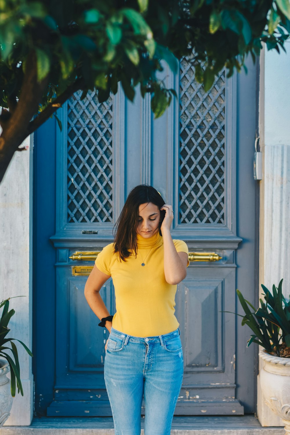 woman standing outside door while holding hair