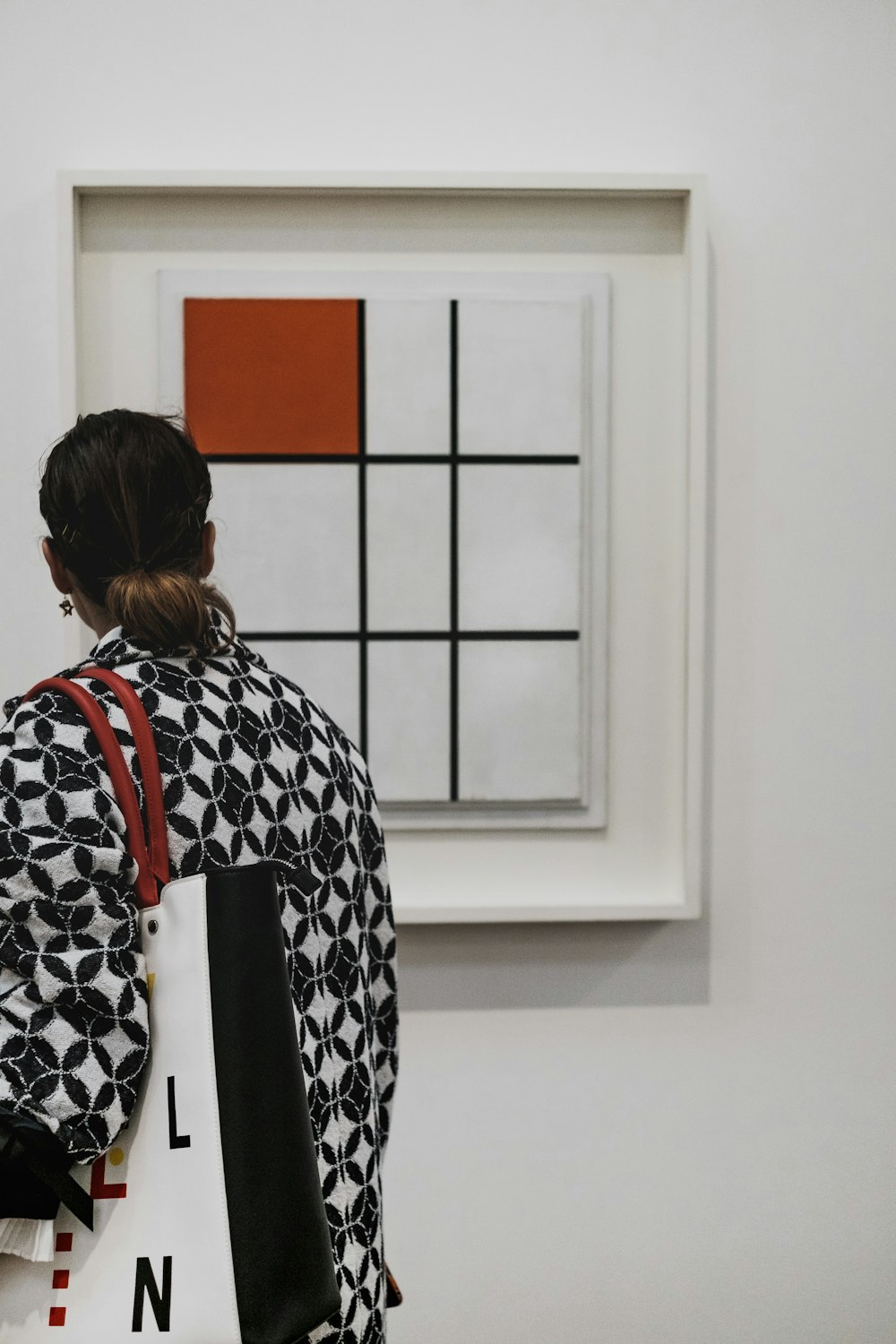 femme portant un sac fourre-tout blanc et noir