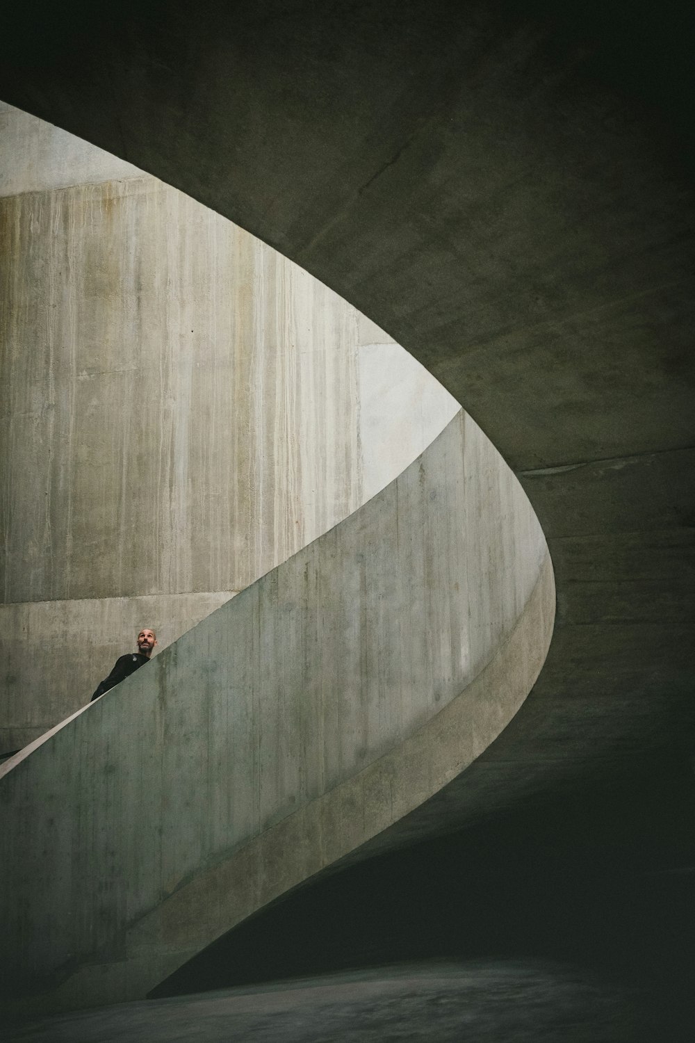 photography of man climbing a spiral stairs