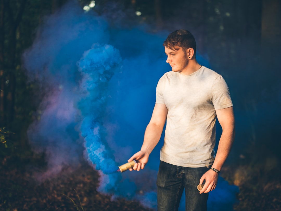 man holding blue smoke bomb