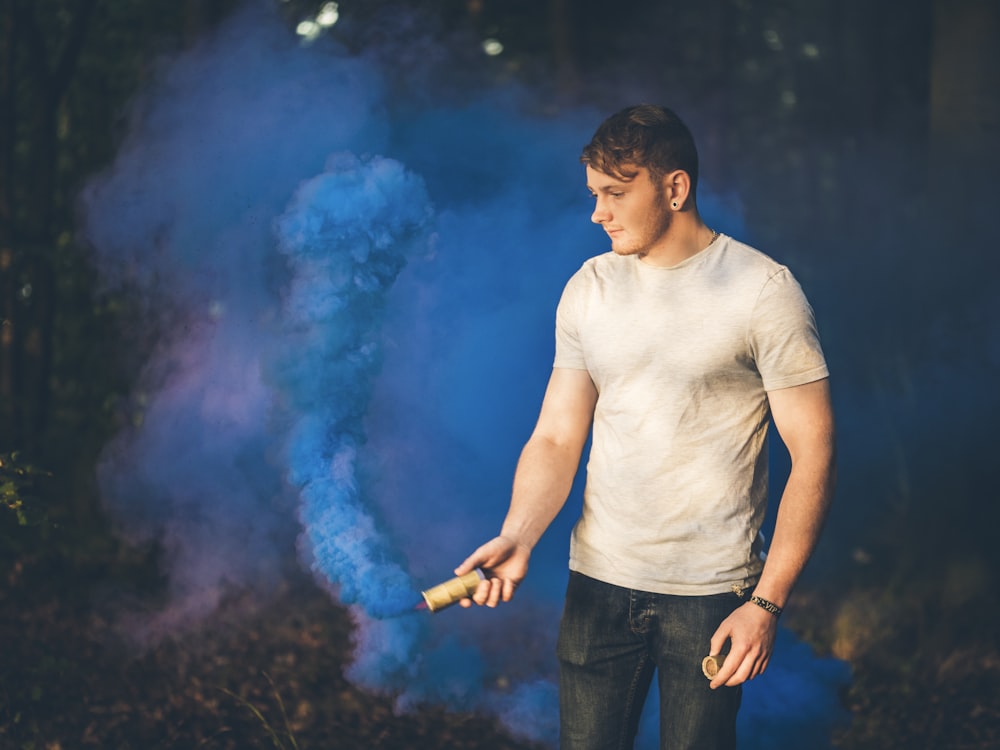 man holding blue smoke bomb