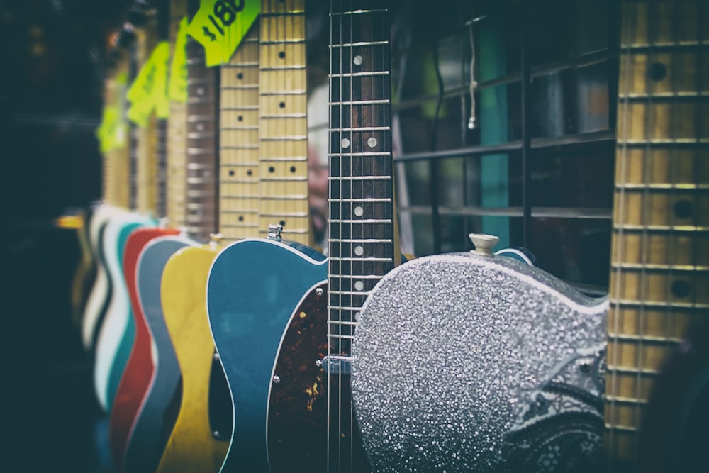 appendere la chitarra di colori assortiti su una rastrelliera di metallo