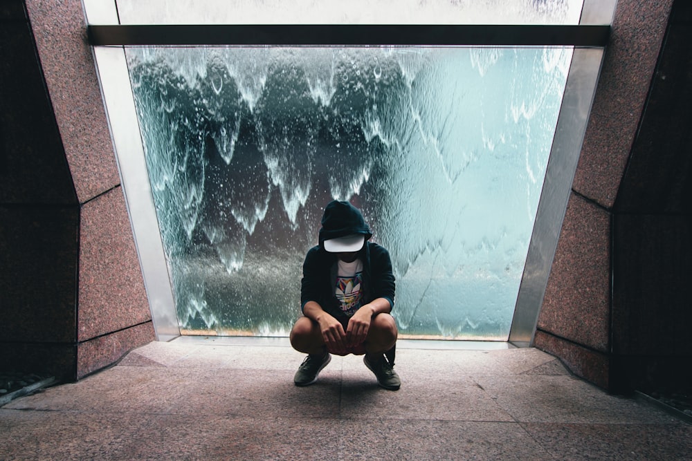 person sitting near glass window