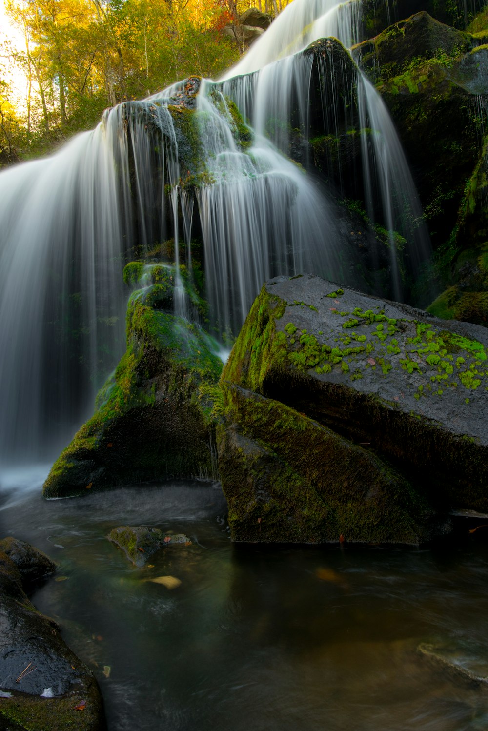 Zeitrafferfotografie von Wasserfällen über moosbewachsenem Felsen