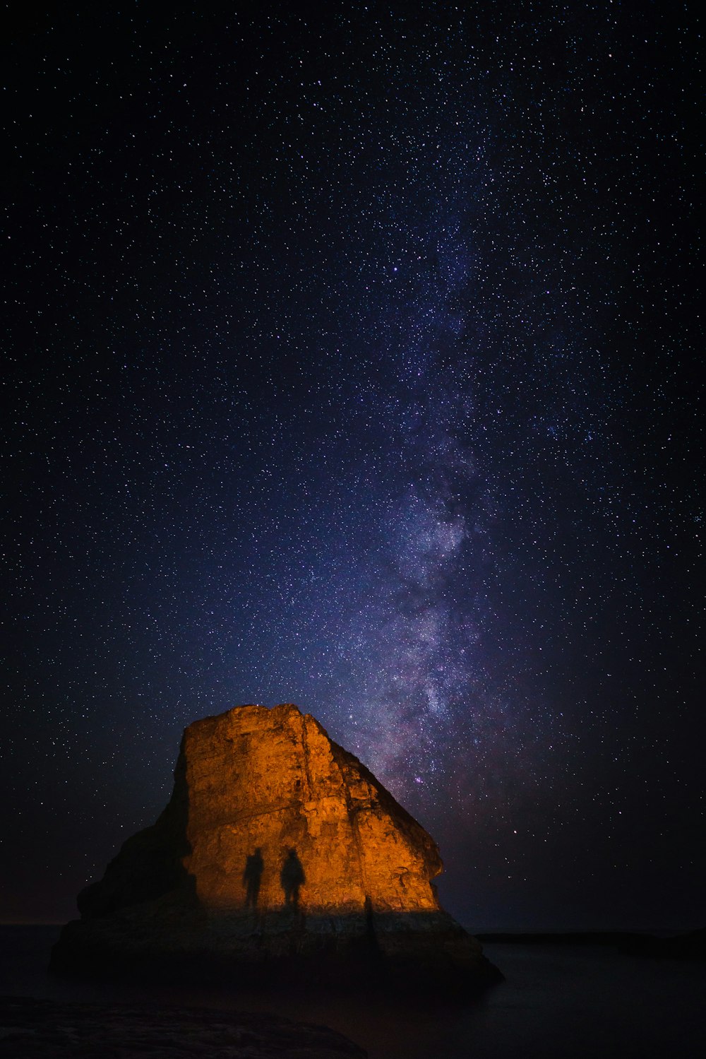 silhouette of two person near stone photo