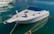 A sleek white boat with a freshly installed bimini on a calm marina background.
