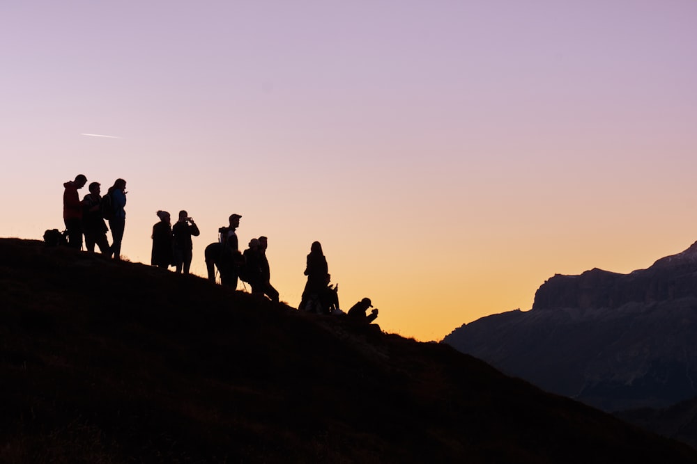 silueta de grupo de personas en la colina