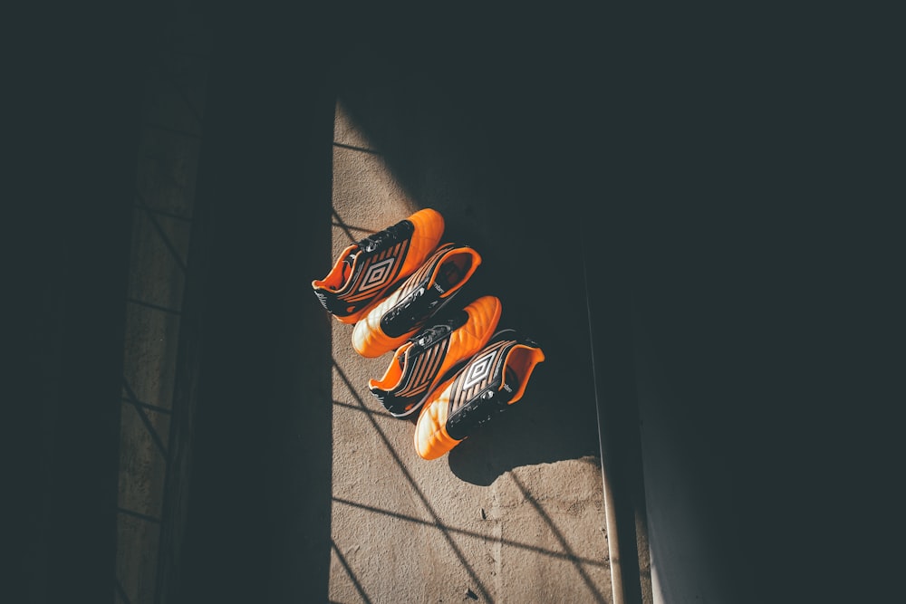two pairs orange-and-black Umbro shoes