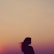 silhouette of woman under orange sky