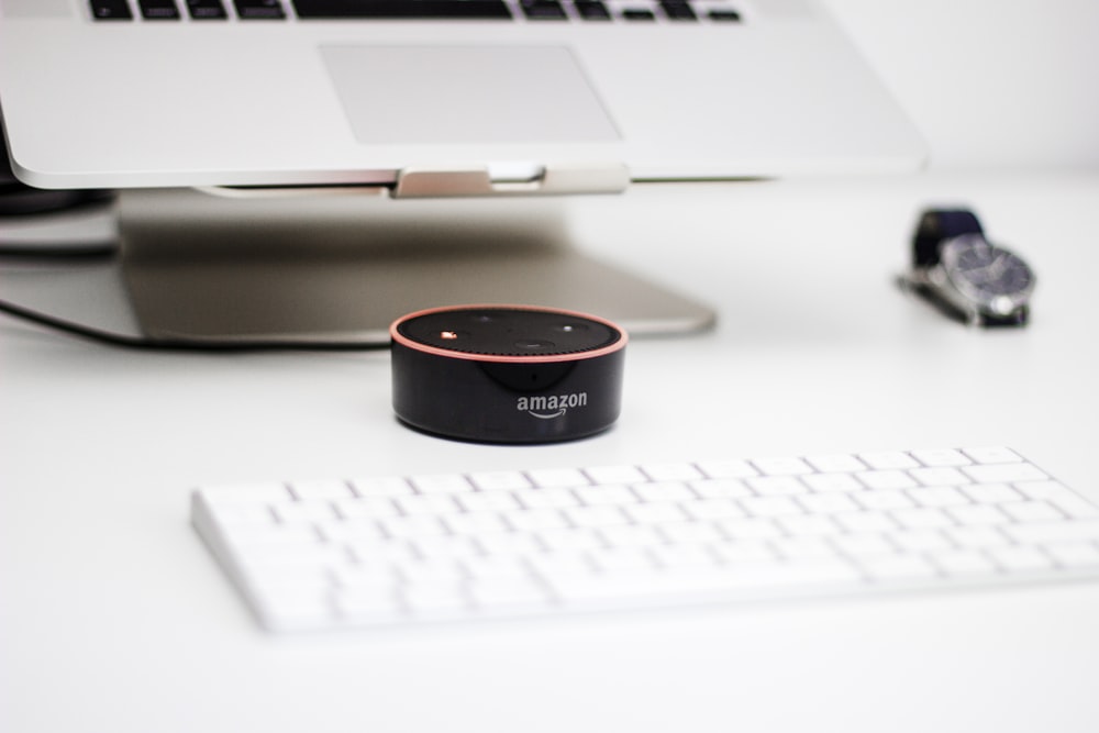 black Amazon Echo Dot speaker beside Apple Magic Mouse