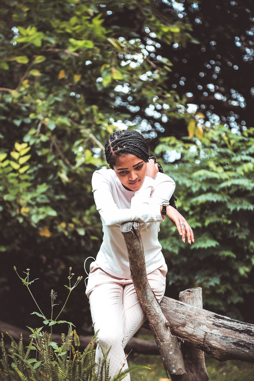 femme assise sur un tronc d’arbre pendant la journée