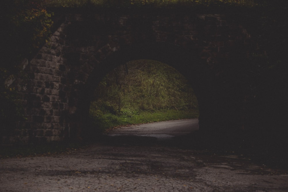 gray road in black concrete brick tunnel