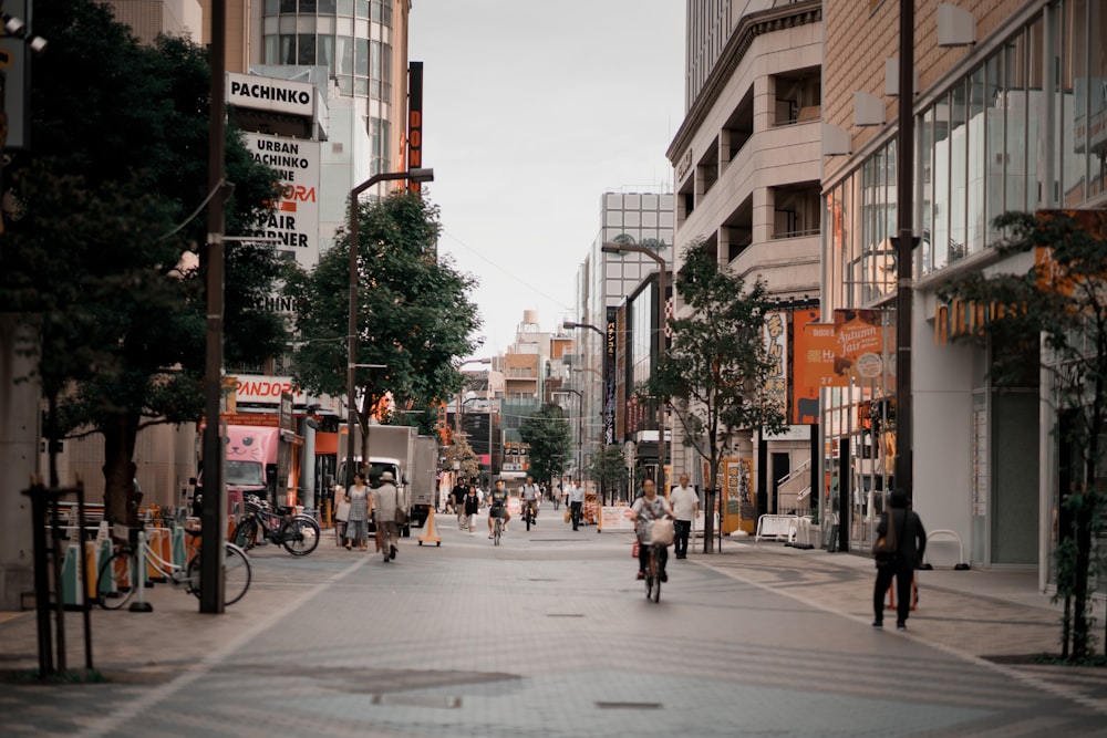 people walking on road between buildings