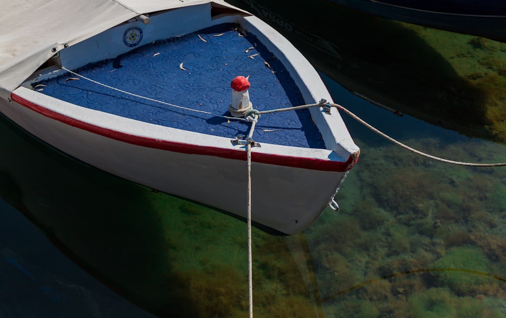 ロープのクローズアップ写真と白と青の木製ボート
