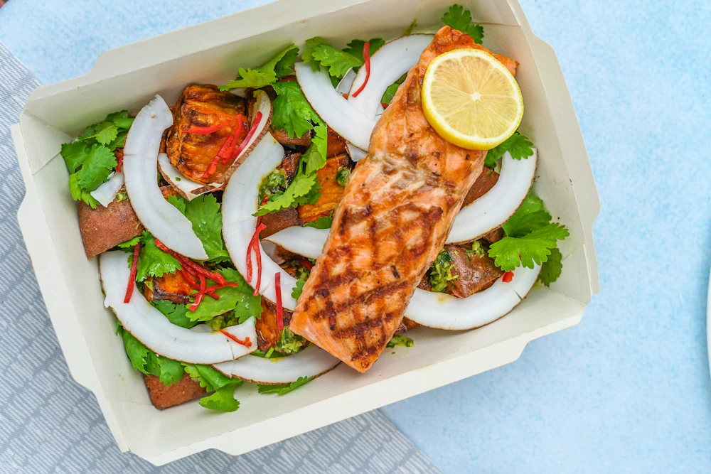 A balanced plate of grilled salmon, greens, and vegetables in natural light