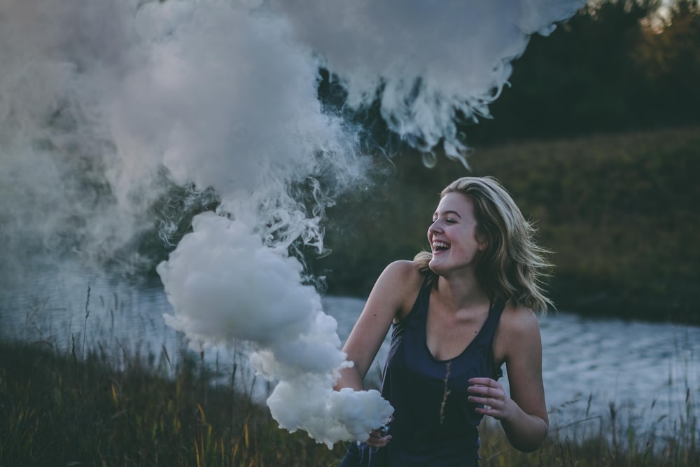 woman laughing while playing with smoke near rover