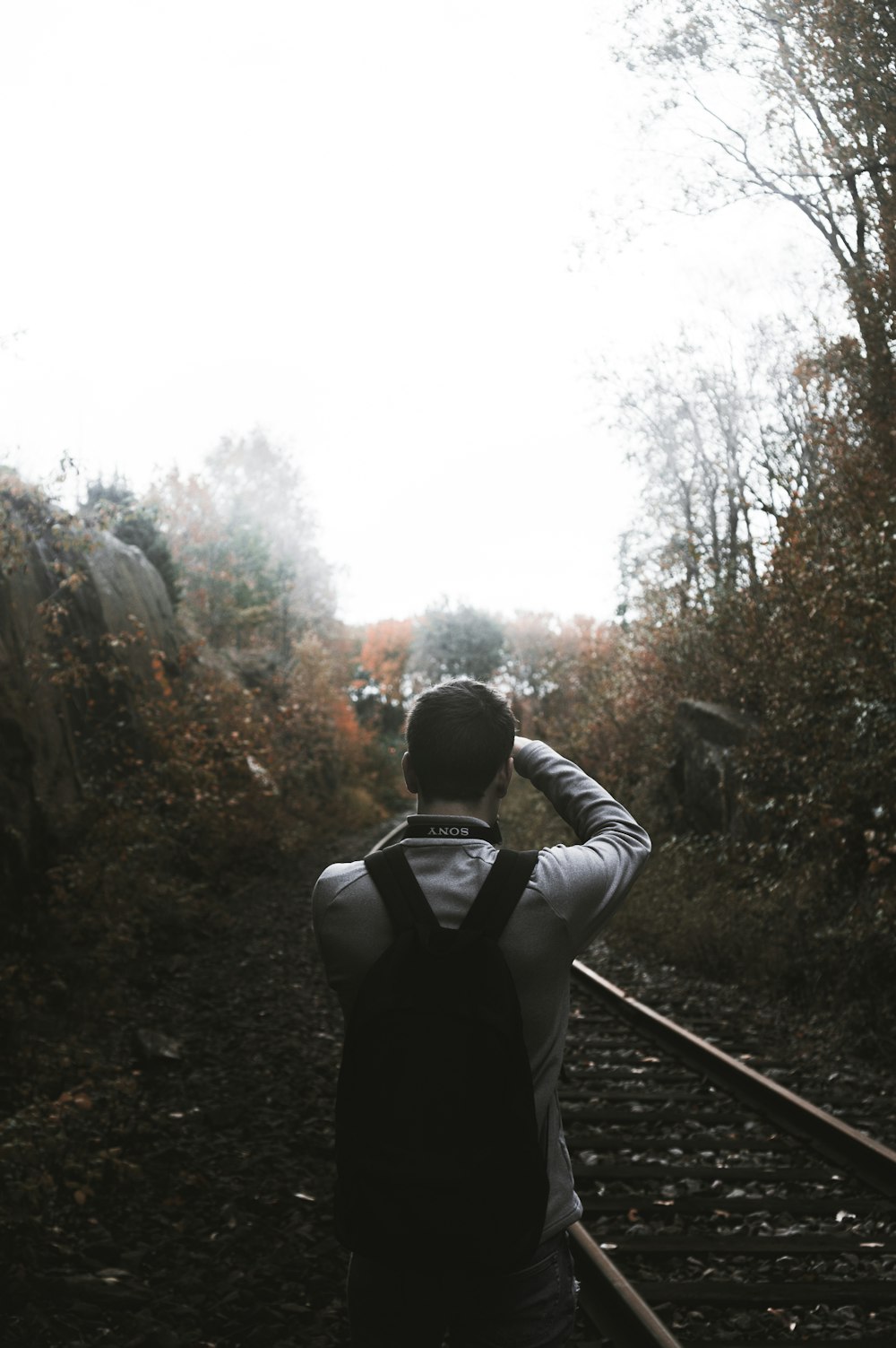 man taking photo beside railroad