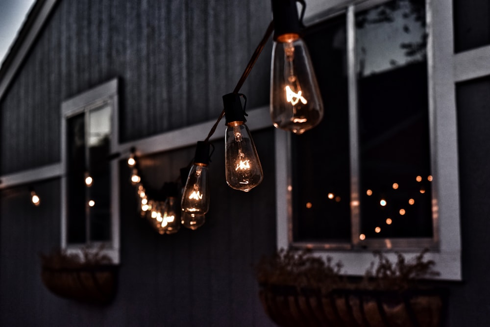 piled hanging lighted bulb beside house