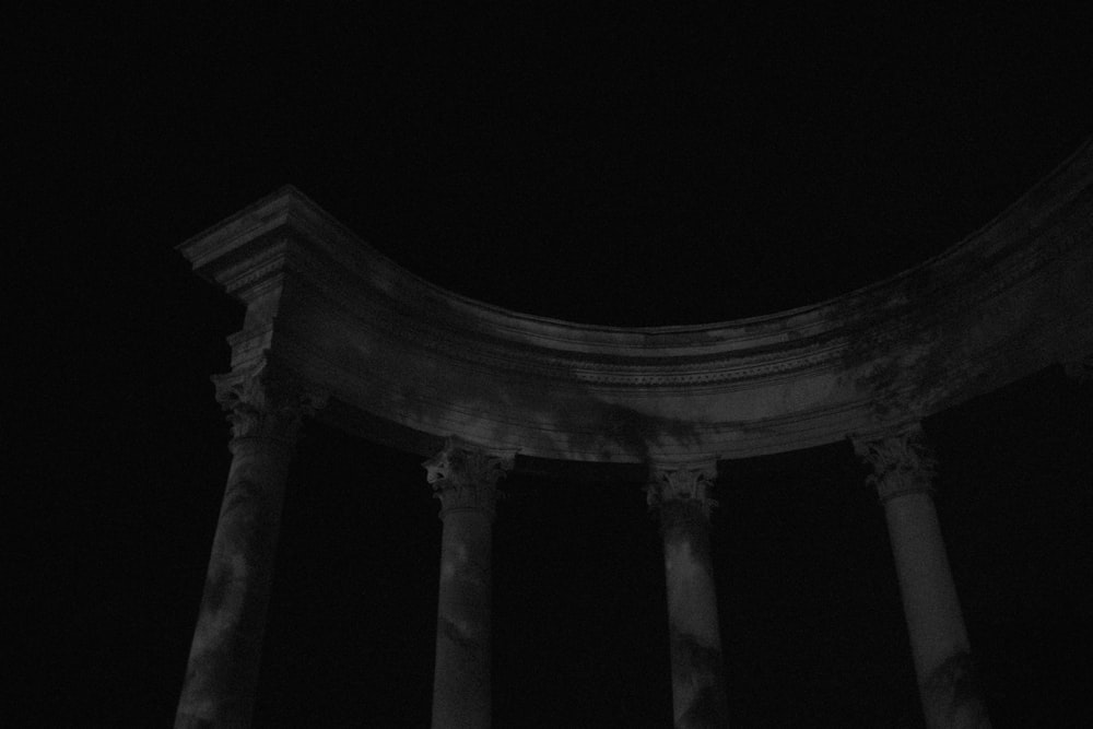 white concrete pillar stand building under night sky
