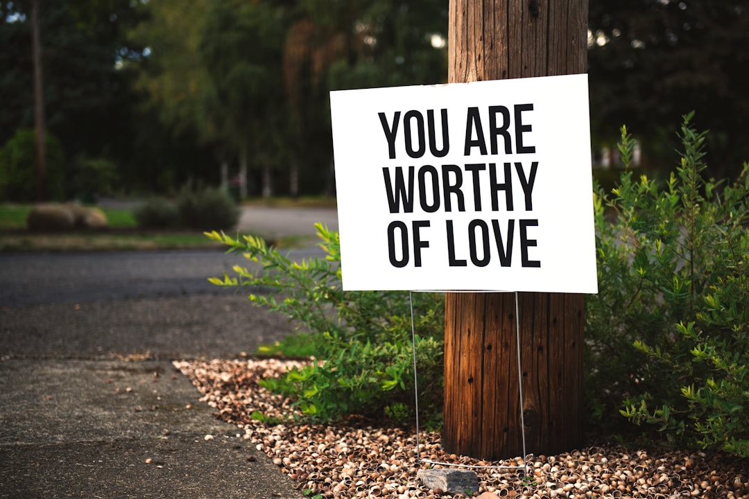 you are worthy of love sign beside tree and road