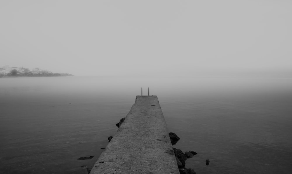 grayscale photography of concrete beach dock