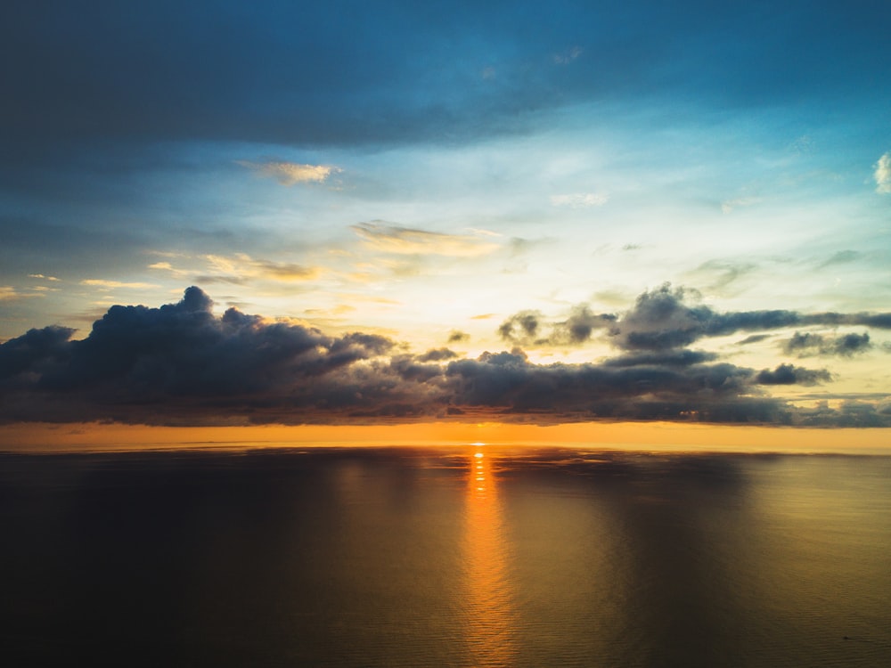 body of water under white clouds