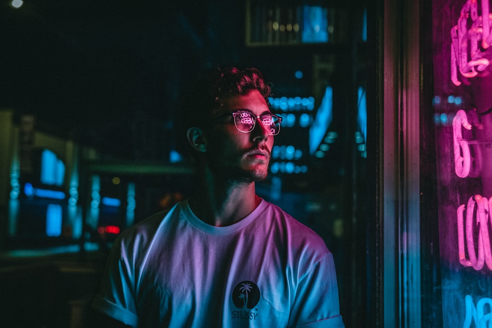 man looking at glass storefront windowpane during night